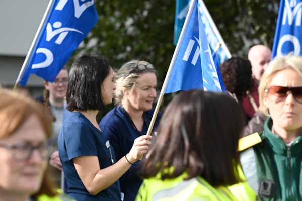 Group of nurses and midwives at a safe staffing protest outside holding INMO flags